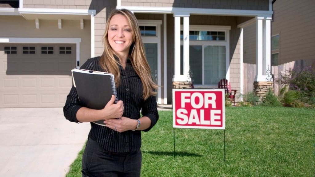 a Home Seller Placing a for Sale Sign in Her Property | Ottawa Property Shop