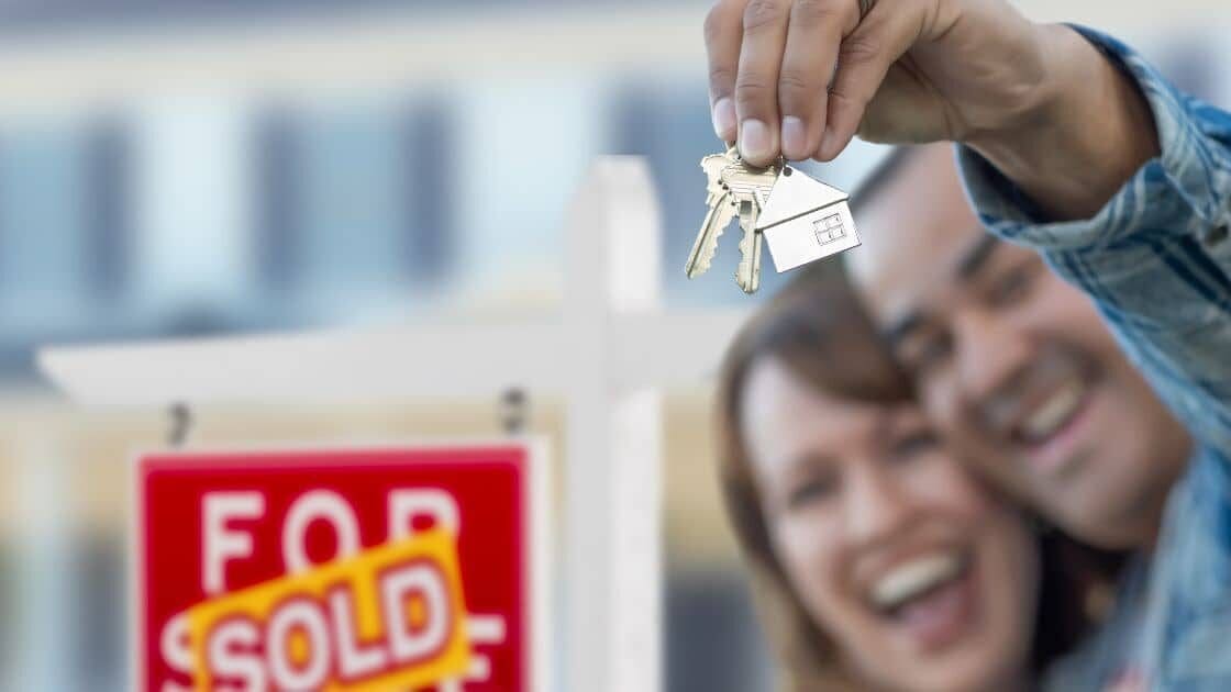 a Happy Couple Holding the Keys to Their New Home After Buying a House in Canada | Ottawa Property Shop